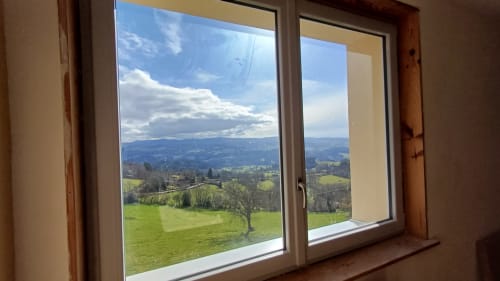 Mountain view from Chambre Passiflore at La Maison de Dun, Saint Racho. Rolling green hills and distant peaks visible through