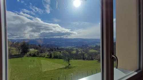 Mountain valley view from Chambre Passiflore at La Maison de Dun, Saint Racho, with green fields and cloudy sky
