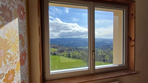 Mountain view from Chambre Passiflore at La Maison de Dun, Saint Racho, showing green valleys and distant peaks through large