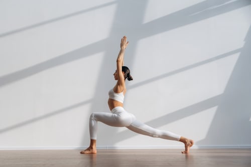 Femme pratiquant le yoga en posture du guerrier au studio bien-être Domaine Alga, Bourg-Charente