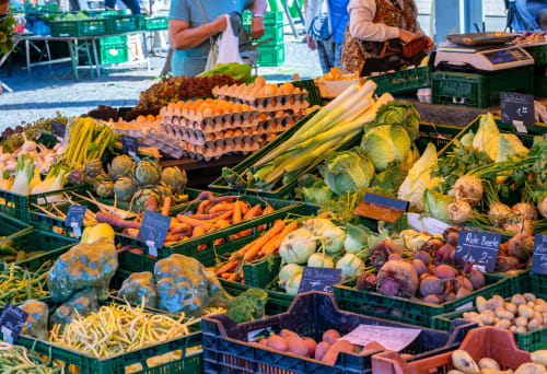 Colorida exhibición de mercado agrícola con verduras frescas, huevos y productos en el mercado de Bussolengo, Italia