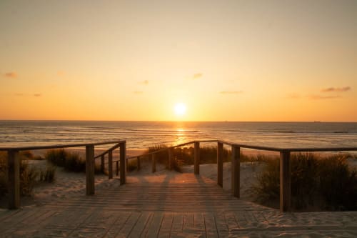 Passadiço de madeira ao entardecer com vista para o Oceano Atlântico, casa de hóspedes em Aveiro, Portugal