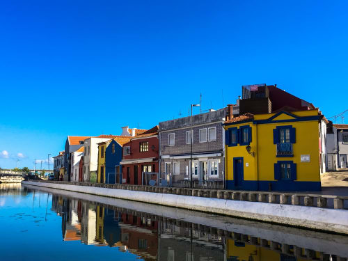 Edifícios coloridos à beira-mar refletindo-se no canal de Aveiro, Portugal