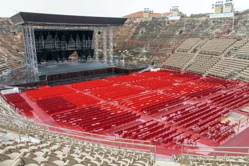 Antiguo anfiteatro romano de Verona con asientos rojos, escenario y arquitectura de ladrillo cerca de Bussolengo, Italia
