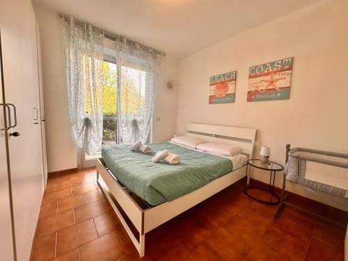 Camera luminosa a Casa Sofia a Varigotti con letto trapuntato verde, accesso alla terrazza, arredamento a tema marino e pavimenti in terracotta