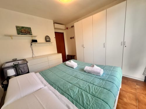 Camera da letto luminosa nell'appartamento Casa Sofia a Varigotti con letto queen size, armadi bianchi e pavimento in legno