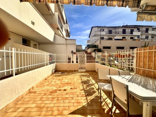 Soleggiata terrazza dell'appartamento Casa Sofia a Ceriale, Varigotti con ringhiere bianche e pavimenti in cotto che si affacciano su edifici