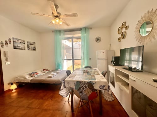 Appartamento Casa Sofia a Ceriale con tavolo da pranzo, letto, TV e vista sulla terrazza verso Varigotti