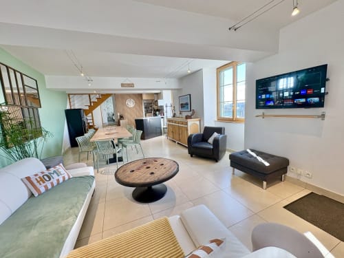 Geräumiger offener Wohnbereich im Gîte La Vue Loire mit Esstisch, gemütlichem Sitzbereich, Fernseher und moderner Küche
