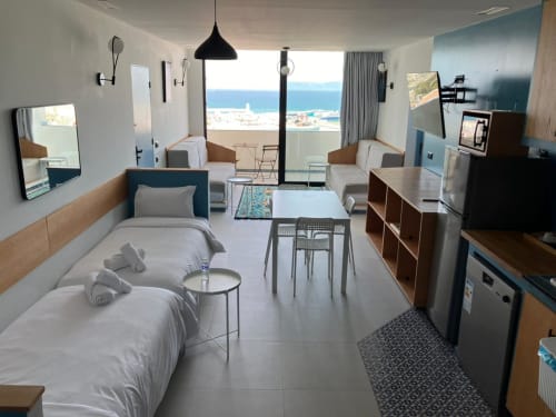 Studio moderne à Tanger avec vue mer, lit, séjour, kitchenette et vista côtière depuis le balcon