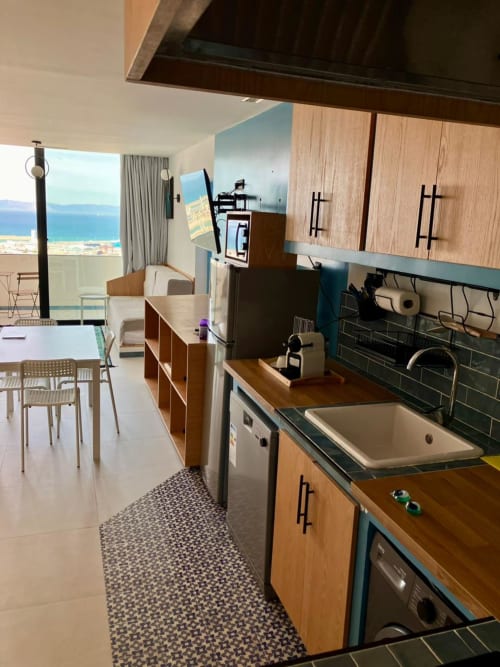 Cuisine moderne d'appartement avec vue sur la mer à l'hôtel de Tanger, équipée de meubles en bois