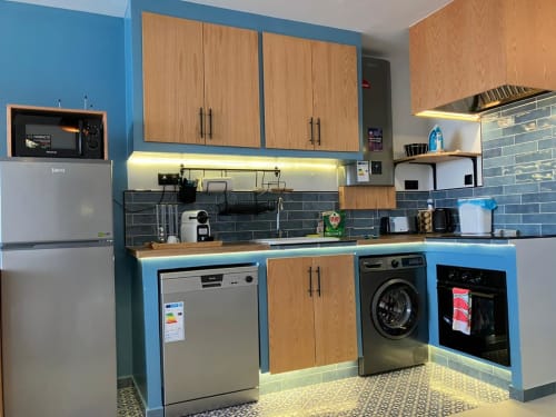 Cuisine moderne de l'appartement bleu YaYaCaSa chez SAMYAflat, Tanger avec murs bleus, meubles en bois et électroménagers inox