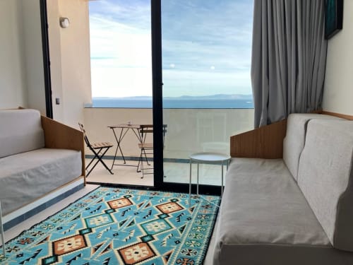 Balcon d'appartement moderne à Tanger avec vue sur mer, mobilier contemporain et tapis géométrique