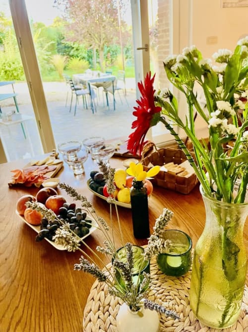 Elegant dining table at Agriturismo CasaViVa with fresh flowers, fruits, and countryside views through open doors