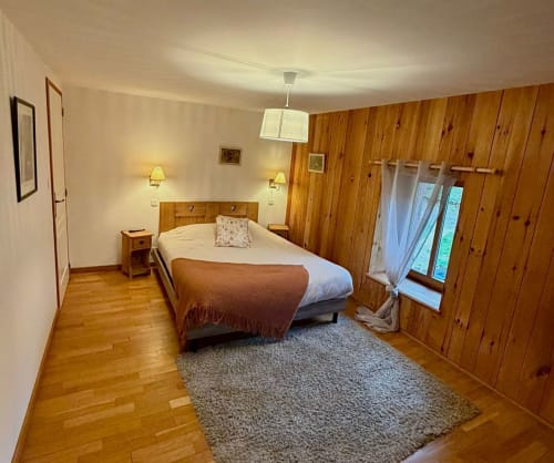 Chambre Églantine à l'Auberge Du Ruxelier à Chéniménil : murs en bois, lit queen-size, parquets et vue sur les montagnes