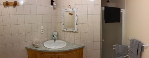 Lavabo blanc rond avec miroir orné et serviettes grises à l'Auberge Du Ruxelier, Chenimenil
