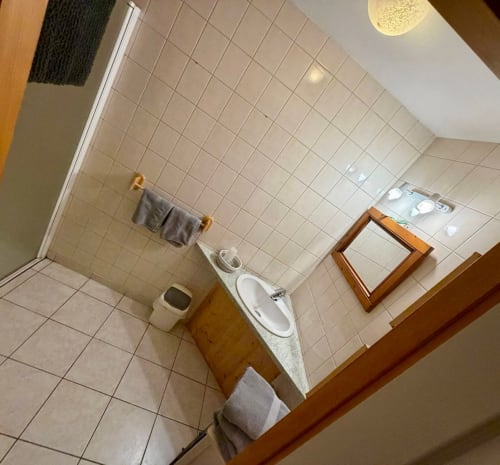 Salle de bain de la Chambre Nature à l'Auberge Du Ruxelier, Chenimenil, avec carrelage blanc, lavabo, toilettes, miroir et serviettes