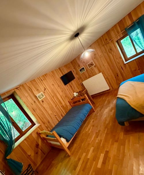 Chambre chaleureuse en bois à l'Auberge Du Ruxelier avec lit, bureau, luminaire suspendu et vue montagne