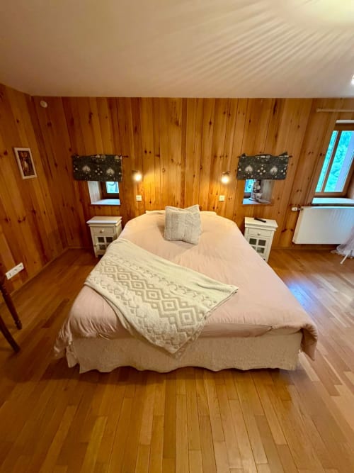 Chambre douillette aux boiseries à l'Auberge Du Ruxelier à Chéniménil, lit queen-size, tables de nuit blanches et vue sur les montagnes