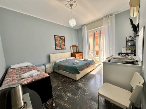 Camera da letto del monolocale La Fenice a Finale Ligure con due letti, vista città e comfort moderni