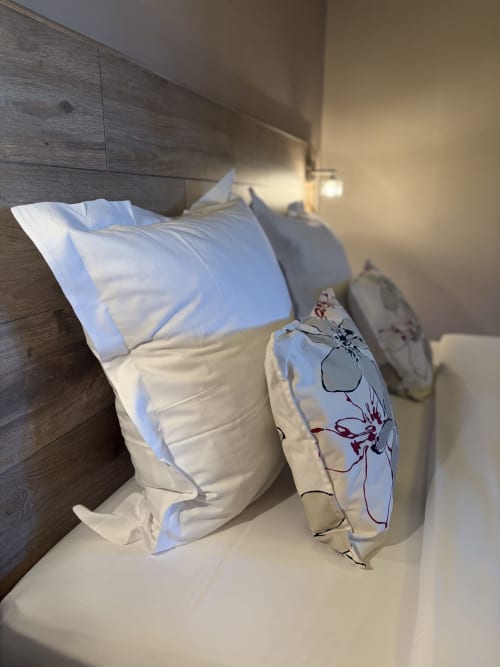 Chambre triple luxueuse à l'Hôtel de l'Ange avec coussins sur lit vue jardin à Niedermorschwihr