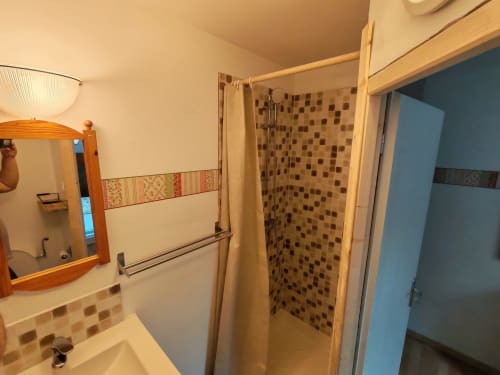 Salle de bains avec douche en mosaïque, meuble-lavabo miroir en bois et décoration beige à La Ressource à Villars-Colmars