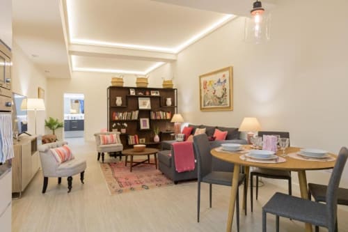 Habitación Almirante B en Calma Places Sevilla: espacioso y moderno con sofá, mesa de comedor, estantería y vistas de la ciudad
