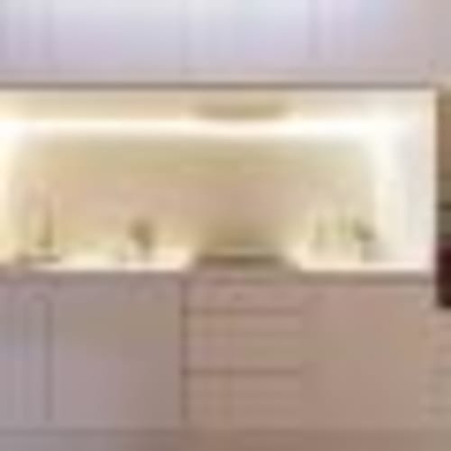 Habitación moderna y luminosa en Calma Places Sevilla con escritorio, televisor de pantalla plana y vistas a la ciudad desde grandes ventanales