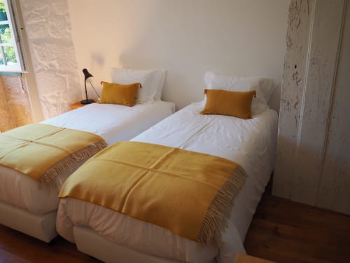 Dois camas de solteiro com roupas de cama brancas e mantas douradas em quarto luminoso da Quinta da Coutada, Arcos de Valdevez, Portugal