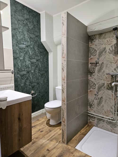 Salle de bain moderne du Gîte Eglantine aux Gîtes Les Muriers, Bourgvilain, avec carrelage botanique vert et parquet