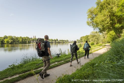 Randonneurs avec sacs à dos marchant le long d'un sentier au bord de la rivière près des Troglos de Beaulieu en Loire