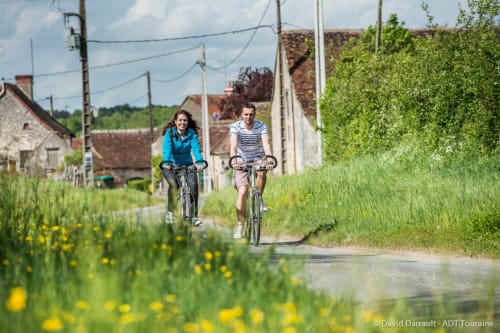 Couple cycling on rural path near Les Troglos de Beaulieu in Touraine, France