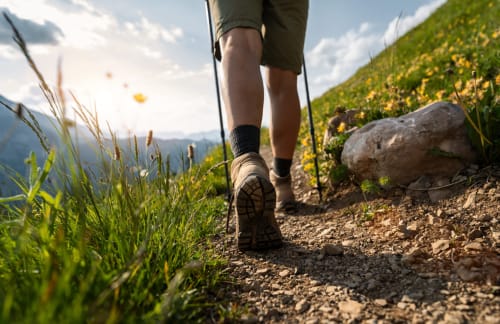Hiker trekking on scenic trail with yellow wildflowers near Beaulieu-les-Loches, France