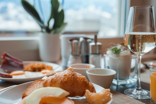 Élégant petit-déjeuner à l'Hôtel Restaurant Le Verdon avec croissant, verre de vin et plantes, vue sur Les Salles sur