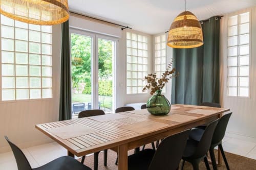 Bright dining room with wooden table, black chairs, woven pendant lights, and garden views at Château Le Conte Saint-Emilion