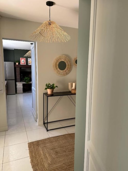 Modern entryway at Château Le Conte Saint-Émilion with woven pendant light, decorative mirror, and console table