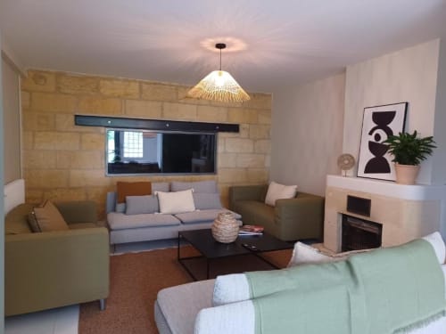 Modern living room in Château Le Conte gîte, Saint-Emilion, with comfortable seating, fireplace, and garden views