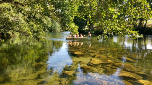 Barco com hóspedes em rio cênico na Quinta da Coutada, Arcos de Valdevez, rodeado por vegetação exuberante