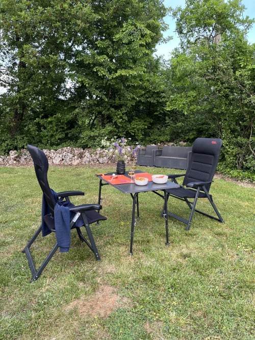 Buiteneetsituatie bij Maison d'hôtes de La Boissière met draagbare kampingtafel en stoelen op het gazon