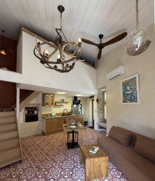 Modernes Ferienstudio in Aiguèze mit offener Küche, Wohnbereich, Deckenventilatoren und Klimaanlage, gemusterten Zementfliesen, im historischen Zentrum gelegen, mit Außenbereich und Blick auf die Stadtmauern.