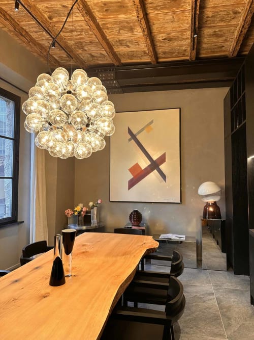 Zona pranzo moderna di Casa_B Como City con tavolo in legno, lampadario bubble in vetro e arte contemporanea