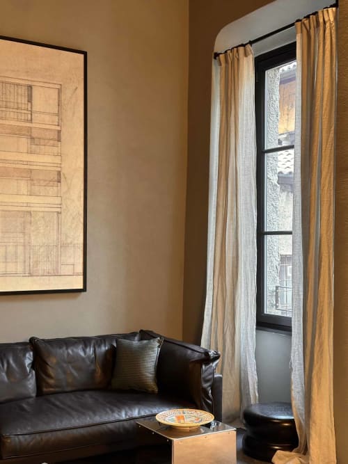 Elegante soggiorno contemporaneo con divano in pelle nera, tende dorate, opere d'arte architettonica e vista sulla città a Casa_B Como