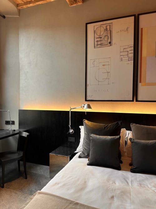 Camera da letto moderna di Casa_B Como City con testata nera, vista sulla città, schizzi architettonici a parete e atmosfera calda
