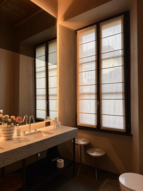 Bagno moderno presso Casa_B Como City con piano in marmo, finestre con vista sulla città e arredi contemporanei