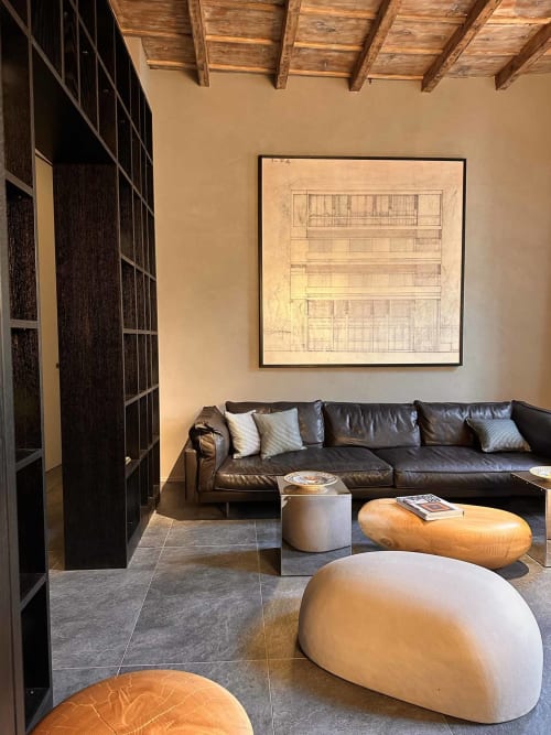 Moderno soggiorno dell'appartamento a Casa_B Como City con divano in pelle nera, travi a vista in legno e opere d'arte architettoniche