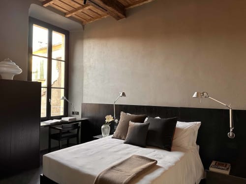Camera da letto moderna in Casa_B Como City con vista sulla città, testata nera, biancheria bianca e soffitto in legno a vista