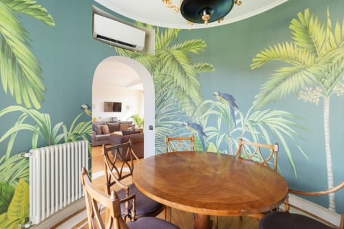 Casa Flaminio dining area at Terrestre Roma B&B in Rome with tropical mural, wooden table, and city views
