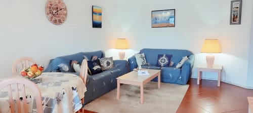 Sala de estar moderna com sofás azuis, acentos rosa e decoração náutica no Sweet Home Estrela do Vau em Portimão