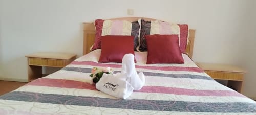 Quarto em Sweet Home Estrela do Vau em Portimão com roupa de cama listrada, almofadas vermelhas e toalhas acolhedoras