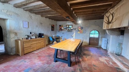 Salle à manger rustique à La Seigneurie du Bois Moreau à Durtal avec poutres en bois, carrelage en terre cuite et table commune